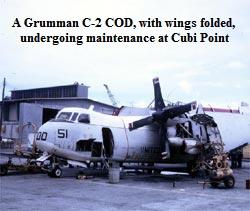 A Grumman C-2 COD, with wings folded, 
undergoing maintenance at Cubi Point